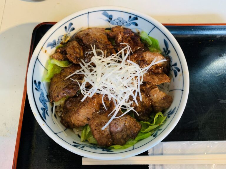 築地どんぶり市場の名物「まぐろほほ肉ステーキ丼」。肉厚なマグロ希少部位を香ばしく焼き上げた、ジューシーな絶品丼