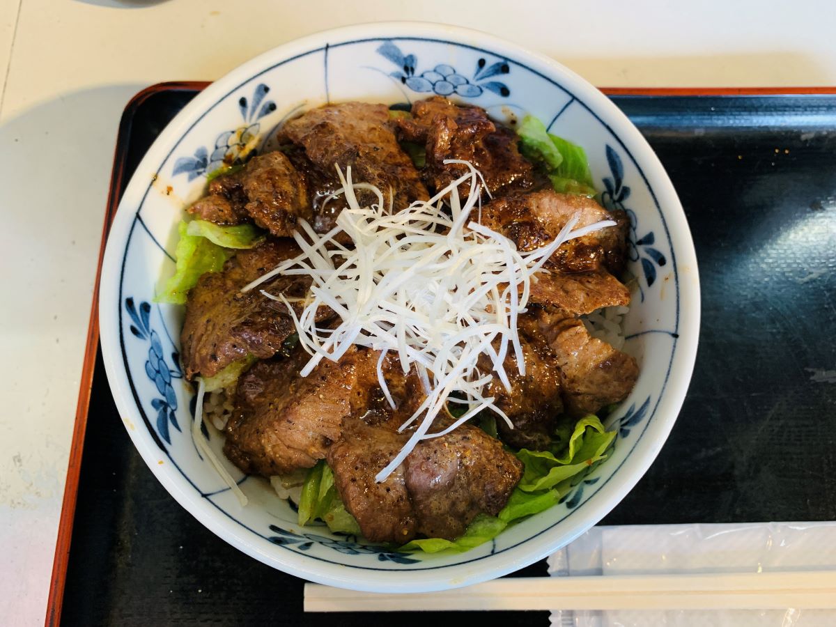 築地どんぶり市場の名物「まぐろほほ肉ステーキ丼」。肉厚なマグロ希少部位を香ばしく焼き上げた、ジューシーな絶品丼