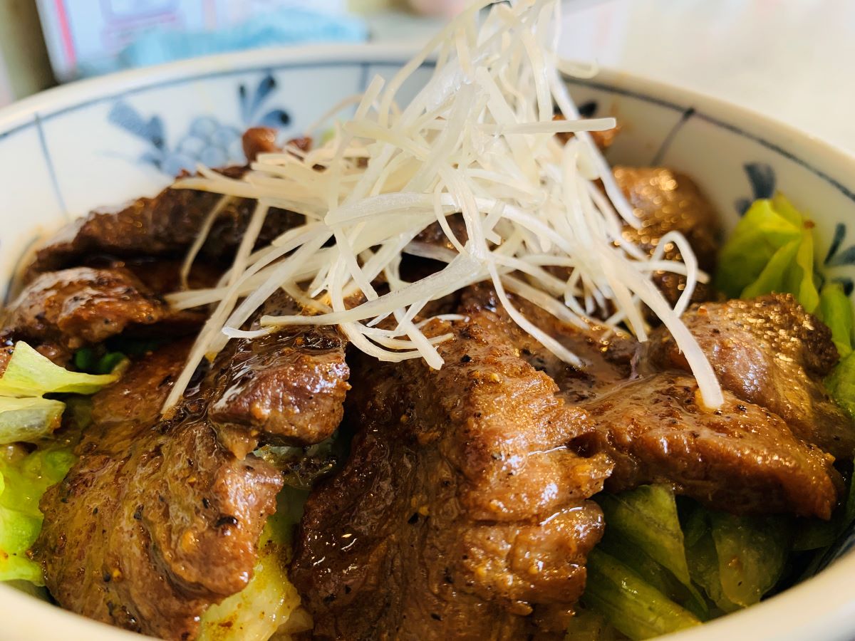 築地どんぶり市場の名物「まぐろほほ肉ステーキ丼」。肉厚なマグロ希少部位を香ばしく焼き上げた、ジューシーな絶品丼