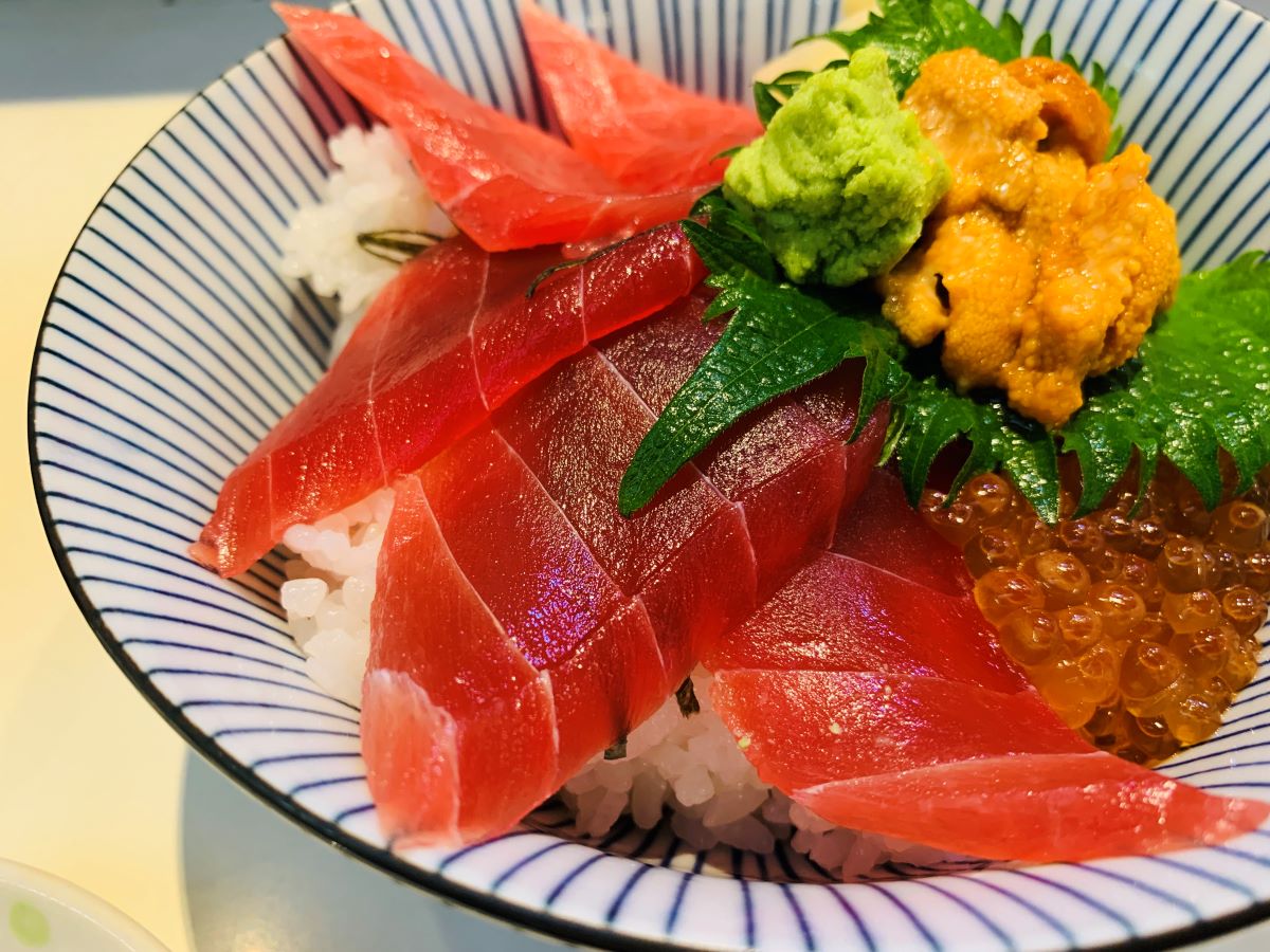 海鮮問屋つきじかんのの「まぐろ入り三種盛り丼」。濃厚なうに、プチプチのいくら、ねっとりしたまぐろ赤身が贅沢に乗った築地場外市場の看板メニュー